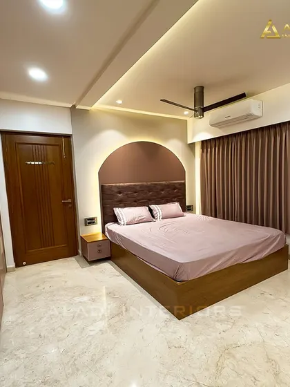 A wider shot of the mauve-themed bedroom, showing the spacious layout and the elegant wardrobe that blends seamlessly with the room's design.