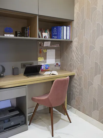 A closer look at the study nook, showing the textured wallpaper and the simple, modern chair. It's a small space, but it's designed to be comfortable and inspiring.