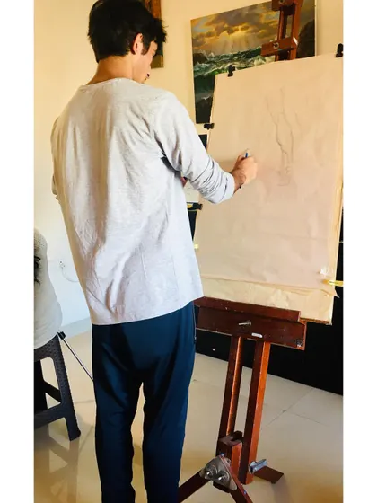 This student is using an overhand or drumstick grip to sketch on a large easel. This technique allows for broader, more expressive strokes, which is great for initial sketches and large compositions. We explore different ways to hold the pencil to achieve different results.