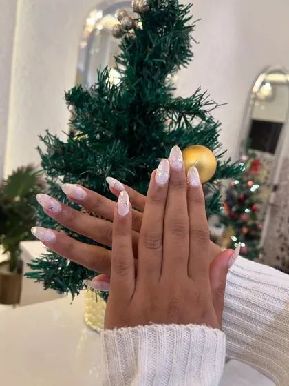 A gorgeous set of winter-themed nails. We used a white marble effect with gold foil flakes to create a look that's reminiscent of a snowy day.