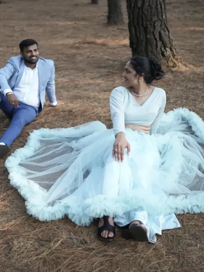 A relaxed moment during a pre-wedding shoot. The ruffled tulle skirt of our light blue gown spreads out for a lovely seated portrait.