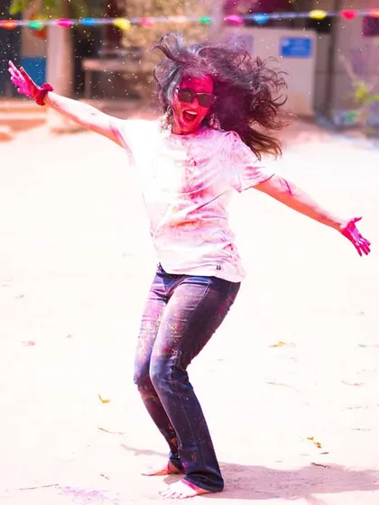 A candid action shot that captures the wild energy of dancing during Holi. These are the moments that make the festival so special.