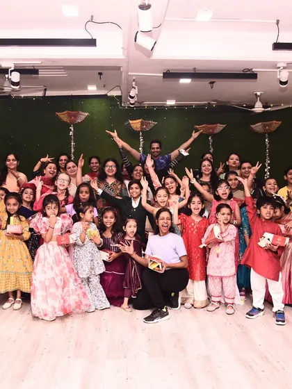 The entire group with hands up, celebrating the spirit of Diwali with energy and excitement.