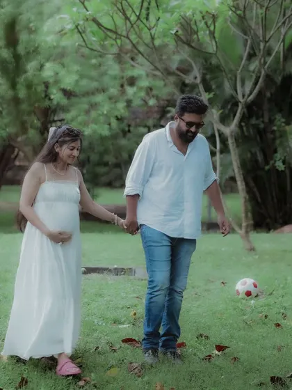 A playful, candid moment of the couple walking in the park. The soccer ball adds a personal touch, hinting at future family fun.