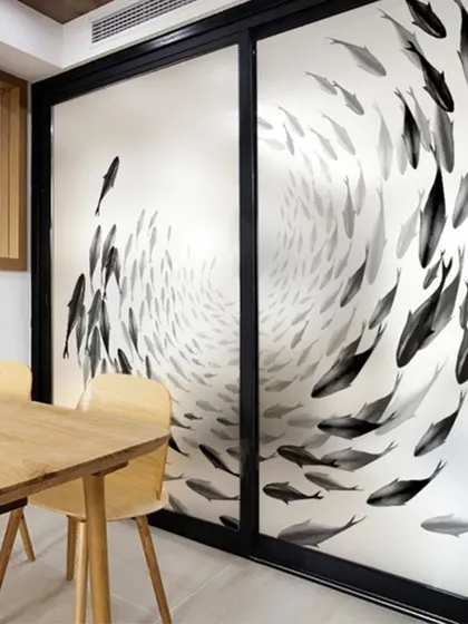 A repeat image of the swirling fish pattern, showcasing its artistic impact on a residential glass partition.