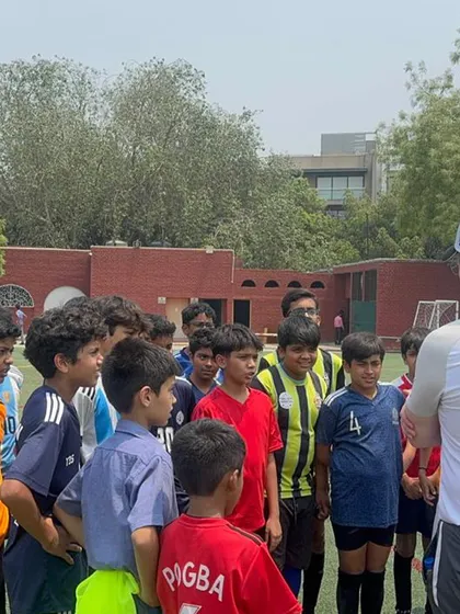 A group of young players huddles around a VfB coach, absorbing every word of advice. These sessions are incredibly valuable for their development.