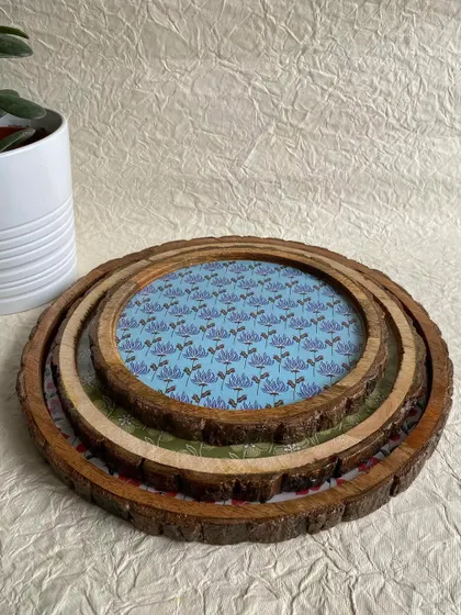 A set of three vintage wooden trays or platters, made from mango wood logs. They can be nested together for easy storage.