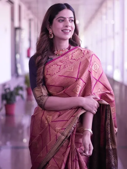 Another pose in the pink silk saree. The rich fabric and intricate weaving tell a story of Indian craftsmanship.