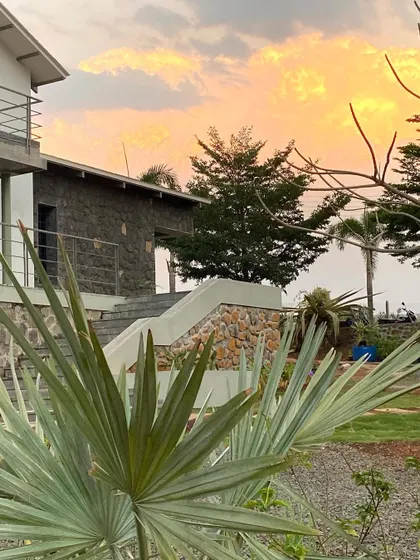 An evening shot of Ranch House under construction. The combination of natural stone and a simple structure creates a powerful silhouette against the summer sky.