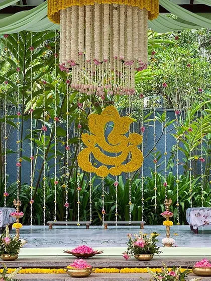 A close-up of the stage, with the floral Ganesha motif and the intricate chandelier.