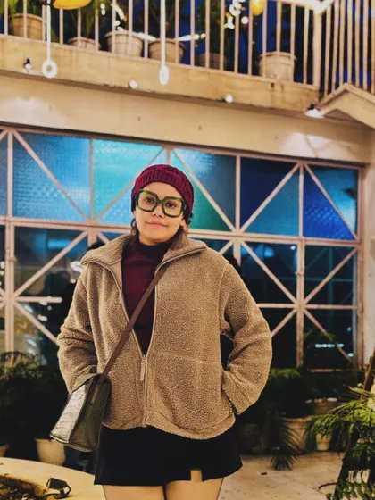 A cozy winter look with a fleece jacket, beanie, and glasses, perfect for a chilly evening out.