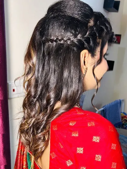 A side view of the hairstyle, showing the soft waves and the delicate braid.