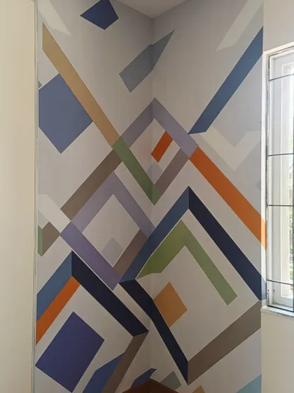 A corner installation of a colorful, abstract geometric mural.
