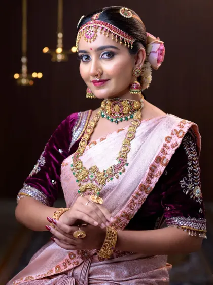 A soft baby pink silk saree paired with a luxurious maroon velvet blouse, creating a royal and elegant bridal look.