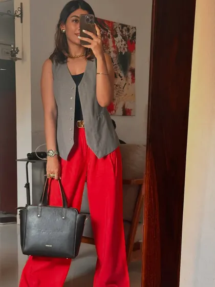 Another example of styling, not labeling. This look, featuring a grey vest and bold red trousers, shows how you can mix formal and trendy pieces to create a unique and powerful outfit for any occasion.