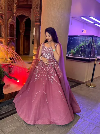 A full view of this magnificent wine-colored ball gown. The cape adds a touch of drama, while the A-line skirt creates a classic and flattering silhouette.