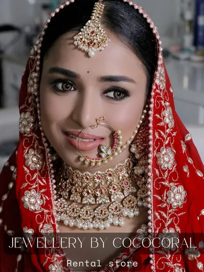 A smiling bride wearing a classic red and pearl choker set from my rental collection. This is a perfect example of how my jewellery looks on the big day.