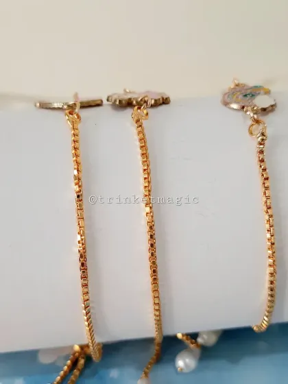 A side view of the adjustable charm bracelets, showing the sliding clasp that makes them easy to fit on any wrist.