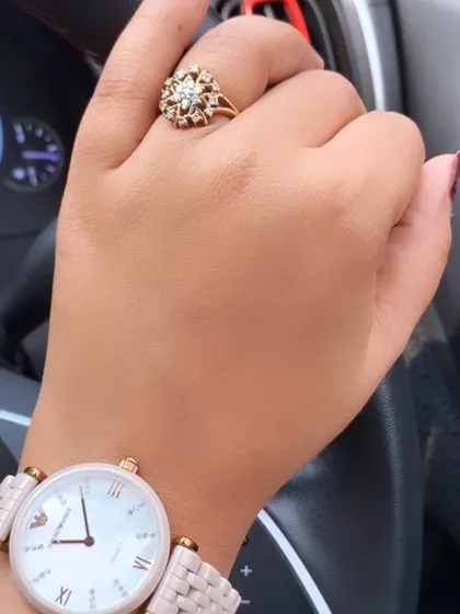 A detail shot of the accessories for a lunch date. A classic watch and a statement ring add a touch of sophistication and personal style.