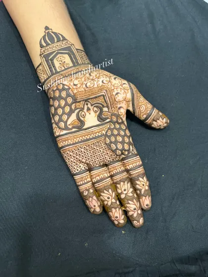 The final, completed peacock design with bold filling. The contrast makes the peacocks the true centerpiece of the hand.