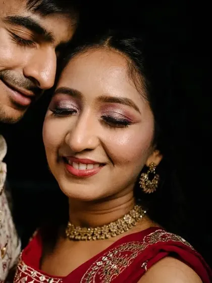 A close-up, intimate portrait of the couple from their Sangeet, highlighting the bride's beautiful makeup and the groom's affectionate gaze.