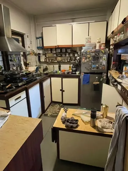 **BEFORE:** A small, crowded kitchen with limited counter space and a wall separating it from the utility area, making it feel dark and impractical.