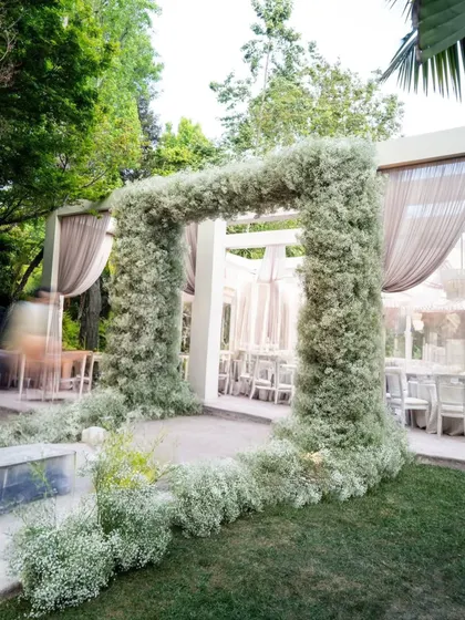 Another angle of the magnificent baby's breath archway, showing how it creates a beautiful frame for the event space beyond. It's a perfect example of a statement floral installation.