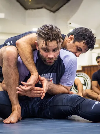 A student practicing a back-take during the BJJ seminar. This is hands-on learning, drilling the techniques shown by the expert instructor.