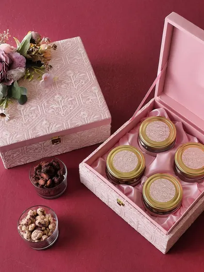 The Chikankari Box in pink is a traditional yet modern gift. It's filled with four jars of our best treats: Rose Cashew, Brownie Bites, Mini Butter Cookies, and Honey Choco Almonds.