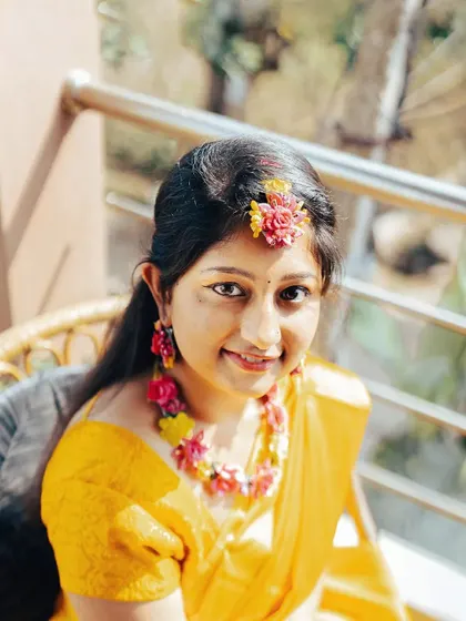 A simple, sun-kissed portrait of the bride on her Haldi day, adorned with floral jewelry.