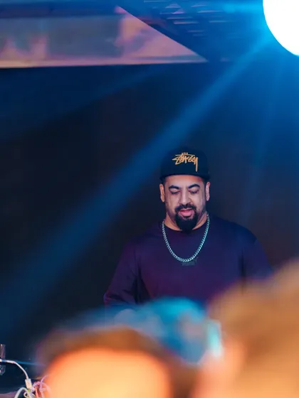 Under the spotlight, focused on delivering the perfect mix of throwbacks and classics for the Friday night crowd.