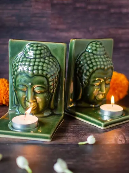 This image captures the tranquil ambiance created by two lit Buddha tealight holders. The soft light enhances the serene expression of the Buddha, making it a beautiful decor piece for evening relaxation.
