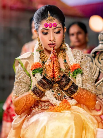 A beautiful candid moment of the bride during her wedding ceremony. Her gold ensemble and traditional jewelry create a look of pure royalty.