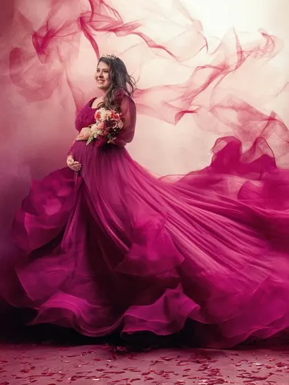 To create a sense of movement and drama, I use techniques like fabric tossing. This captures the magenta gown in full flight, surrounding the mother-to-be in a cloud of color and energy.