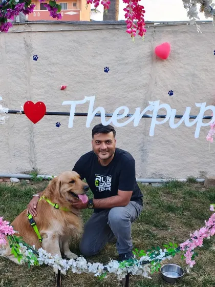 A guest poses with a golden retriever at our 'I Love Therpup' photo booth. It's a popular spot for capturing the happy vibe of our cafe.