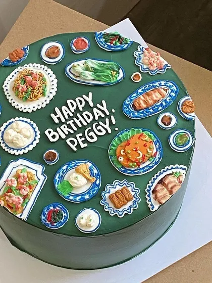 This cake features a spread of classic Chinese dishes on traditional blue and white patterned plates, showcasing incredible attention to detail.