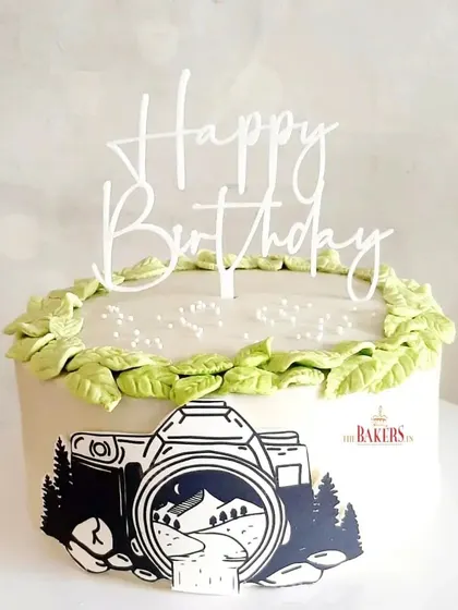 A thoughtful cake for a photographer. This minimal-fondant design features a beautiful camera silhouette against a nature backdrop, with a leafy green border.