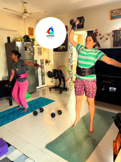 A client performs a jumping dumbbell press, a plyometric exercise that builds explosive power and cardiovascular endurance.