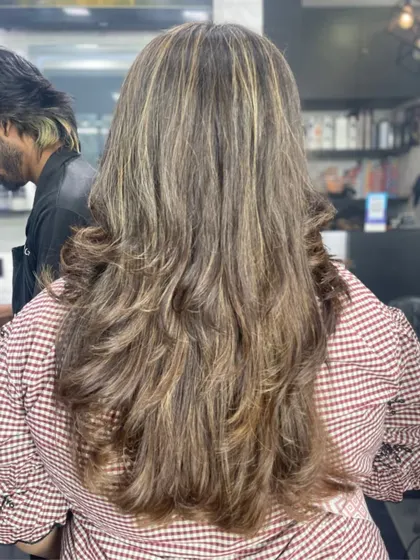 The back view of a long, layered haircut with highlights, showing off incredible texture and volume.