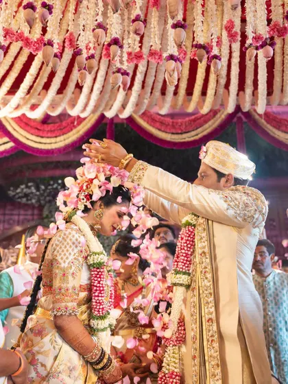 A candid moment from the wedding ceremony, capturing the bride and groom during the rituals. Jhanvi's entire ensemble, from her blouse to her saree, comes together to create a truly memorable bridal look.