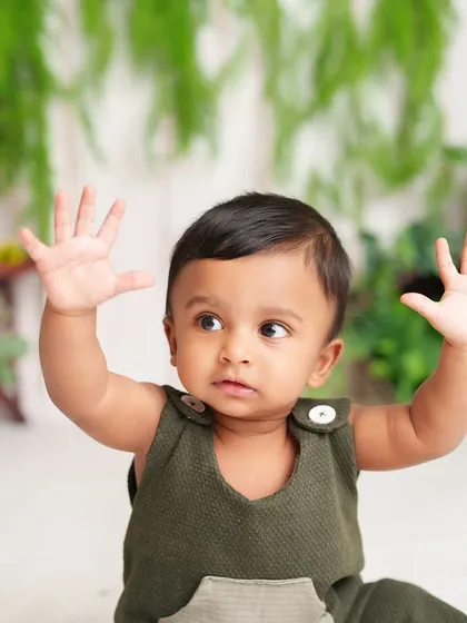 "Stop, in the name of cuteness!" This little boy's playful pose with his hands up is an adorable and funny moment from his sitter session.