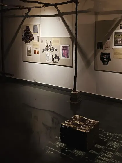 Another view of the installation, showing the raw wooden supports and the box of punch cards.
