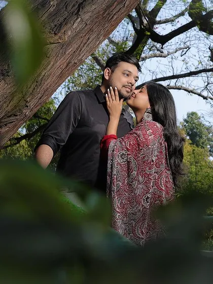An intimate pre-wedding portrait framed by nature. This shot captures a tender moment between the couple during their outdoor shoot.