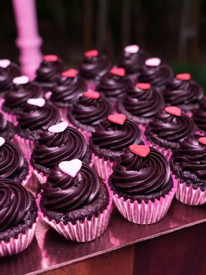 Mini chocolate ganache cupcakes with tiny hearts, created for a pink-themed bachelorette party. These bite-sized desserts are always a crowd-pleaser.