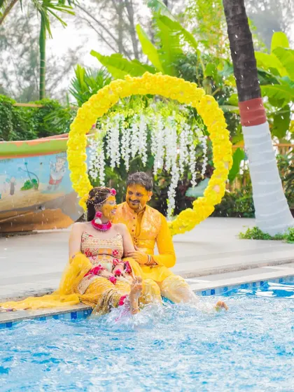 A fun and unique Haldi shot, with the couple dipping their feet in the pool to cool off after the ceremony.