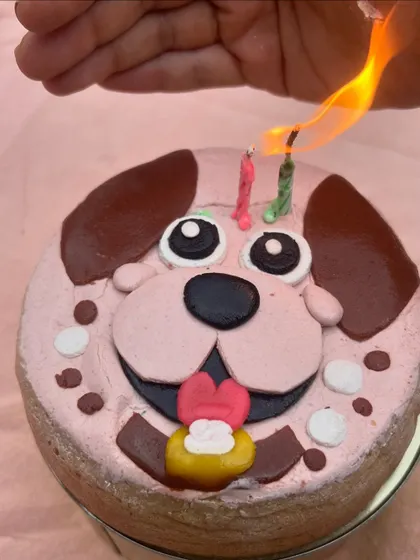 Lighting the candles on a custom dog-face cake. This is the moment right before the birthday chaos begins, and we love being a part of it.