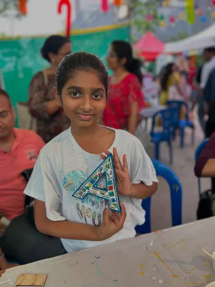 A participant with her finished mosaic art initial. This is a popular activity at my pop-up stalls.