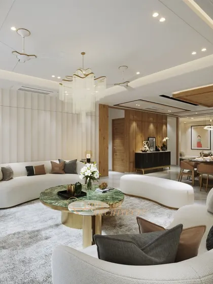 A wide view of a living and dining area where soft, curved sofas and a striking green marble coffee table create a focal point. The design balances modern forms with timeless materials.
