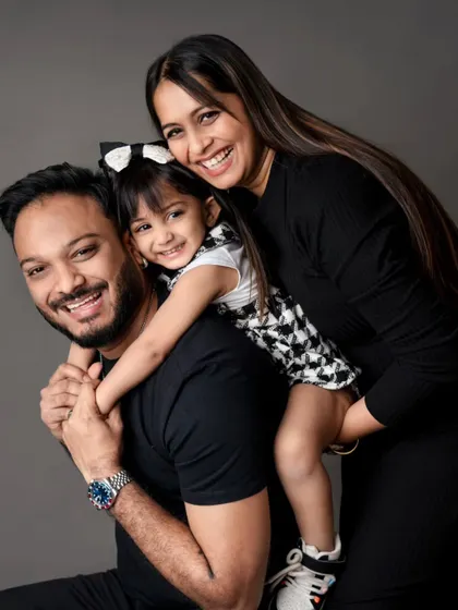 A classic piggyback pose that is always full of smiles. This family portrait against a solid grey backdrop is both fun and timeless.