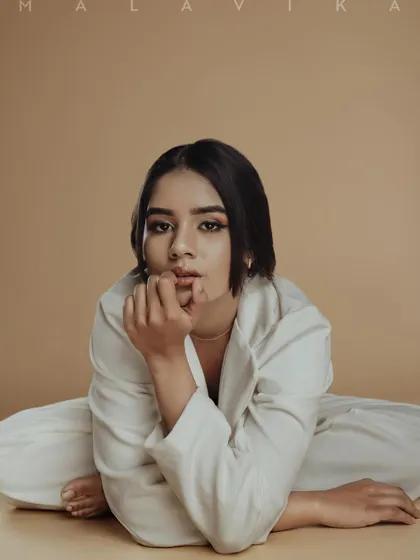 A minimalist and modern editorial look. The makeup is clean and subtle, focusing on sharp brows and a defined eye shape to create a powerful, high-fashion statement.